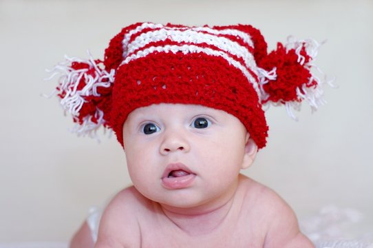 Portrait of the baby in a red knitted hat (3 months)