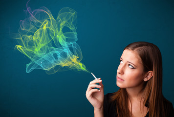 Obraz premium Pretty lady smoking cigarette with colorful smoke