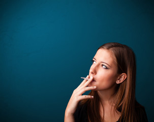 Beautiful woman smoking cigarette vith copy space