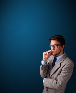 Young man smoking cigarette with copy space