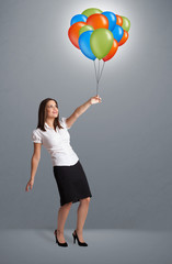 Young woman holding colorful balloons