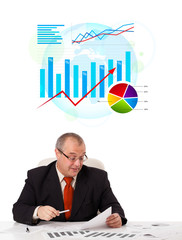 Businessman sitting at desk with statistics