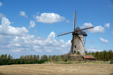 Fototapeta na wymiar Old windmill on cloudy sky