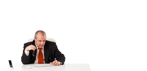 businessman sitting at desk and typing on keyboard with copy sca