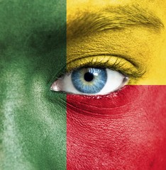 Human face painted with flag of Benin