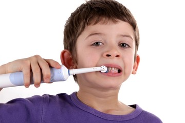 Boy brushing teeth with electric toothbrush - obrazy, fototapety, plakaty