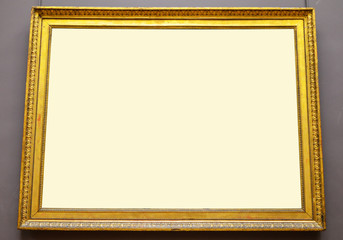Fototapeta premium Empty golden picture frame hanging on wall