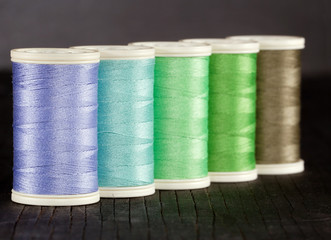 Colorful spools of thread on dark background
