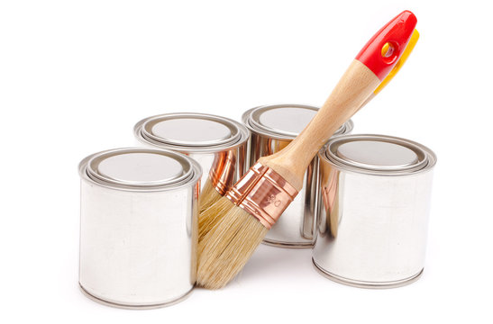 Cans of paint with paintbrushes isolated on white