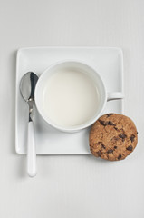 Closeup top view of cup with milk and cookie