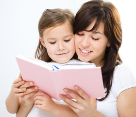 Mother is reading book with her daughter