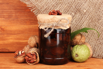 jam-jar of walnuts on a wooden background