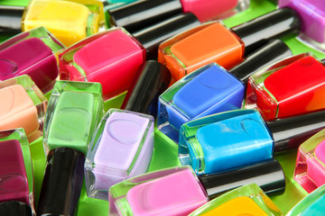 Group of bright nail polishes, on green background