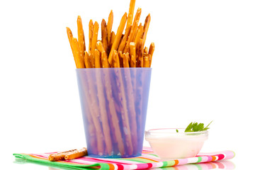 Tasty crispy sticks in purple plastic cup isolated on white