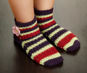 Legs female in striped socks on laminate floor