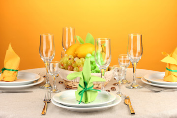 Table setting in green and yellow tones on color  background