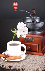 Cup of coffee with coffee mill on wooden table