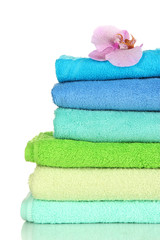 Stack of towels with fragrant flower isolated on white