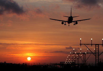 Fototapeta na wymiar Lądowanie samolotu w zachodzie słońca