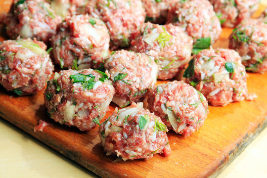 Raw meatballs on the chopping board