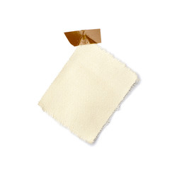 Petit morceau de toile sur fond blanc tenu par de l'adhésif