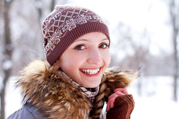 Smiling girl on a background of a winter park outdoors