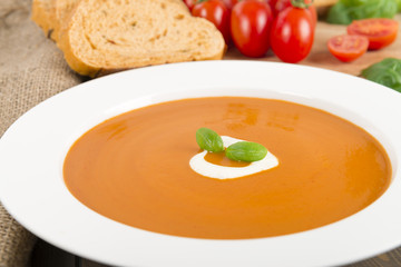 Cream of tomato soup with crème fraîche, bread & basil leaves