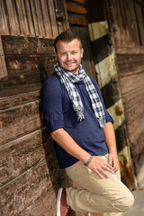 Man posing leaning against wooden wall fashion