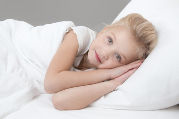 cute little girl resting in the bed closeup