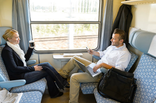 Man And Woman Sitting In Train Talking