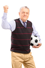 A happy mature fan with football gesturing with his hand