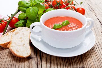 Frische tomatensuppe in einer weißen suppentasse mit basilikum