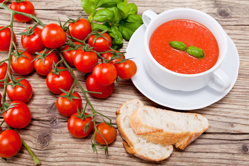 Frische tomatensuppe in einer weißen suppentasse mit basilikum