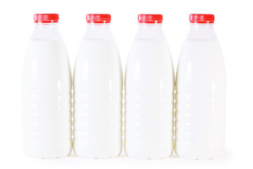 Four bottles of milk with red cap isolated on white background.