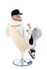 Rapper in yellow jacket sits on yellow chair