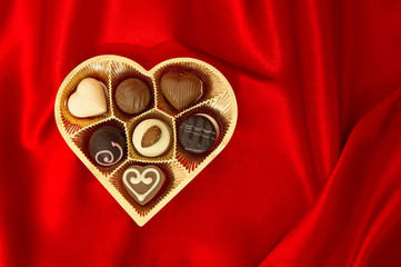 chocolate pralines in golden heart shape box