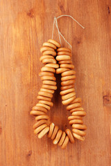 tasty bagels on rope, on wooden background