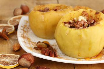 Baked apples on plate on wooden table