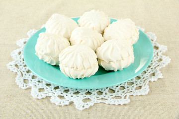 Marshmallows on color plate on light background
