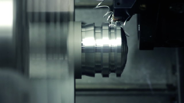 CNC milling machine makes some steel part on a factory