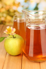 Full glass and jug of apple juice and apple