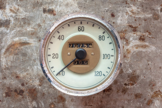 Vintage car speedometer on a rusty background