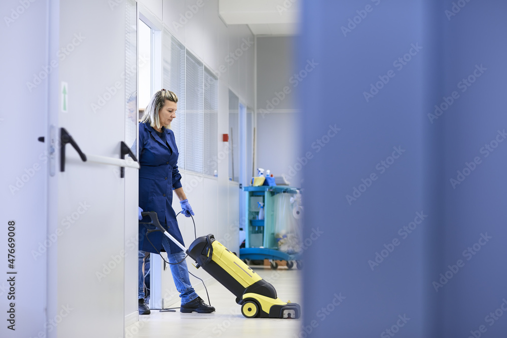 Wall mural women at workplace, professional female cleaner washing floor in