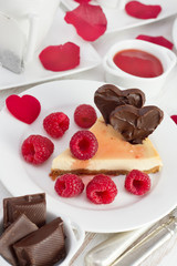 cheesecake with raspberries on the plate with cups of tea