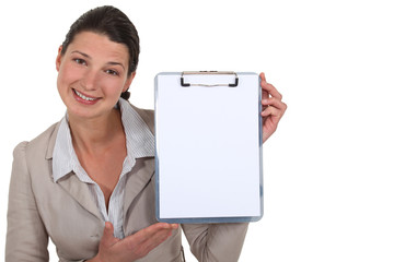 Brunette presenting blank clip-board