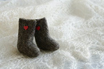 Tiny felted valenki with hearts on knitted downy shawl