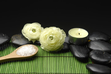 Fototapeta na wymiar ranunculus flower and stones on green mat