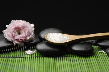 Obraz na płótnie Canvas herbal salt in spoon with stones and ranunculus flower