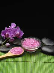 salt in wooden spoon and orchid and stone