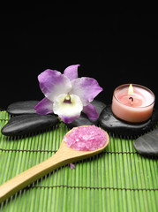 Fototapeta na wymiar Sól w łyżka z różowa orchidea z świeca na matę